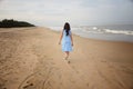 Back view of indian woman walking across beach Royalty Free Stock Photo