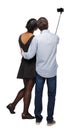 Back view of an interracial couple that makes selfie on selfie stick Royalty Free Stock Photo