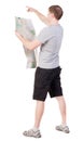 Back view of journey young man looking at the map and pointing Royalty Free Stock Photo