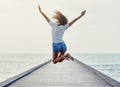 Back view of jumping girl on the pier