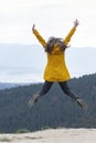 Back view on jumping girl on top of mountain. Happy tourist woman conquered the top. Freedom and tourism Royalty Free Stock Photo