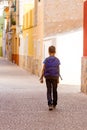 Back view of kid with backpack outdoors in european city.