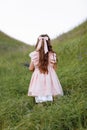 Back view of little child girl with long hair decorated silk hair bow wearing stylish pink vintage dress with lace Royalty Free Stock Photo