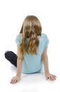 Back view of little girl is bored, sitting on floor. Isolated on white background Royalty Free Stock Photo