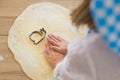 BACK VIEW: Little girl hands on a dough on a table