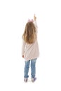 Back view of little girl points at wall. Rear view