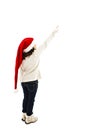 Back view of little girl in red Santa hat points at wall Royalty Free Stock Photo