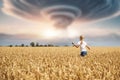 Back view little kid girl walking ripe wheat field imagined nuclear bomb explosion mushroom dramatic cloud background