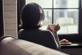 Back view of lonely ÃÂaucasian young woman enjoying having breakfast with cup of hot coffee, cappuccino and croissant Royalty Free Stock Photo