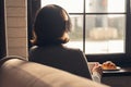 Back view of lonely ÃÂaucasian young woman enjoying having breakfast with cup of hot coffee, cappuccino and croissant Royalty Free Stock Photo