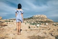 Back view of lonely woman standing on rocky desert
