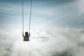 Lonely young woman with swing above cloud