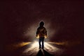 Back view of lost child was standing in the middle of a street lit by the headlights of cars in the dark background. People and Royalty Free Stock Photo