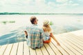 Back view of lovely couple man and woman sitting near river or lake hugging and relaxing. Nature Summer relationship Lifestyle