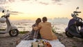 Back view of loving couple enjoying the view, watching sunset on the beach outside the city Royalty Free Stock Photo