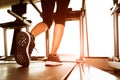 Back view of lower body legs of fitness girl running on machine or treadmill in fitness gym with sun ray. Warm tone. Healthy and Royalty Free Stock Photo