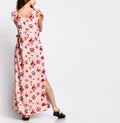 Back view of Luxurious young slim girl with long hair in a long dress with floral print. Royalty Free Stock Photo