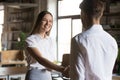 Male boos handshake excited female employee greeting with promotion