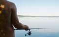 Back view of male fisherman fishing on sunny summer day outdoors, copy space. Royalty Free Stock Photo