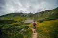 A back view of male hiker in a leather hat, with a backpack, on the trail leading to the top of Mount Spitsy, Carpathian Mountains Royalty Free Stock Photo