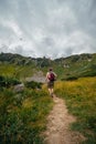 A back view of male hiker in a leather hat, with a backpack, on the trail leading to the top of Mount Spitsy, Carpathian Mountains Royalty Free Stock Photo