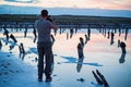 Back view male outdoor photographer at salt lake Baskunchak in Russia