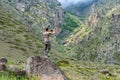 Male hiker takes photo of beautiful mountains in North Caucasus in summer