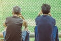 Back view of male parents cheering their childrens playing football