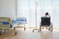 Back view, Male patient having stressed and sitting on wheelchair in hospital room. Royalty Free Stock Photo