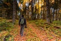 Back view male photographer in bright autumn forest
