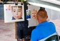 Back view male street painter make art using colorful pencils