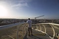 Back view of a male traveler taking a picture of a cityscape