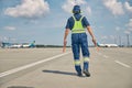 Signalman with wands going along the runway