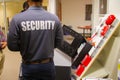 Back view of a male wearing a black SECURITY shirt testing fire alarms