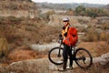 Back view of a man with a bicycle and red backpack against the blue sky. cyclist rides a bicycle. Royalty Free Stock Photo