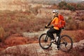 Back view of a man with a bicycle and red backpack against the blue sky. cyclist rides a bicycle. Royalty Free Stock Photo