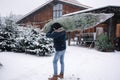 Back view of man carries Christmas tree to his home. Man buy fir tree and take in to the car. Winter mood Royalty Free Stock Photo