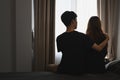 Back view of man embracing his wife and sitting in bed room. Comforting, encouraging and understanding. Royalty Free Stock Photo