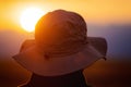 Back view of a man with explorer hat watching scenic sunset. Concept for travel exploration and discovery. Royalty Free Stock Photo