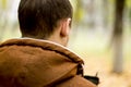 Back view of man with headphones holding mobile smart phone Royalty Free Stock Photo