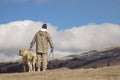 Back view of a man with his dog on a high hill enjoyi Royalty Free Stock Photo