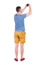 Back view of man photographing. tourist in shorts. Royalty Free Stock Photo