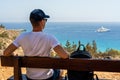 Back view of man relax on bench sitting near the sea. Wanderlust concept Royalty Free Stock Photo