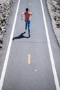 Back view of man running on the road. Athletic young man running outdoor.