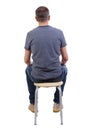 Back view of a man sitting on a chair