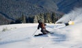 Man skiing on prepared slope with fresh snow. Snow gun machine making artificial snowfall. Magic nature on background. Royalty Free Stock Photo