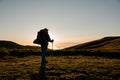 Back view man standing on the hill field with hiking backpack and sticks Royalty Free Stock Photo