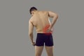 Back view of man suffering from pain in his right side isolated on grey background Royalty Free Stock Photo