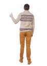 Back view of man in sweater shows thumbs up.