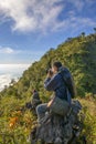 Back view of a man is taking photo with camera.